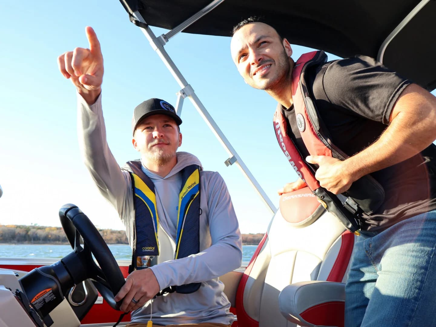 A BoaterWise instructor pointing out a maneuver to a student at the helm